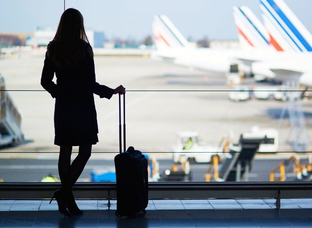 Mujer viajando sola usando aplicación móvil en aeropuerto